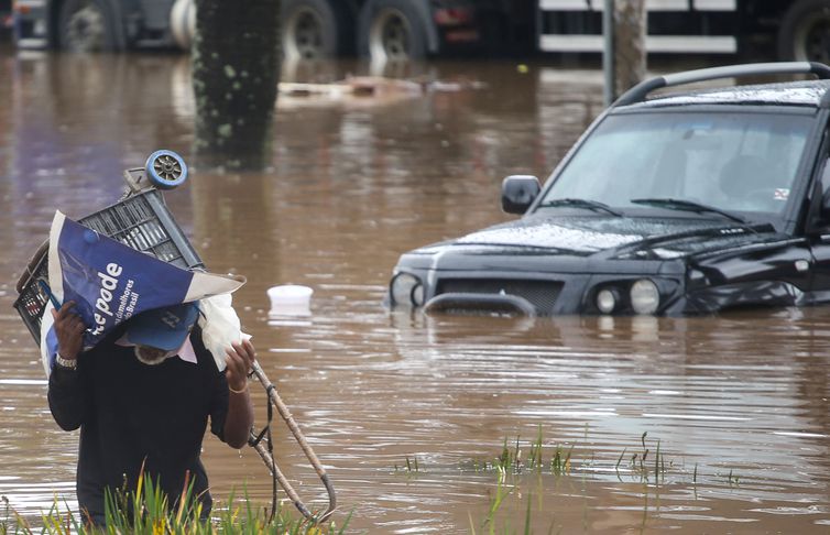 Um homem caminha por uma rua inundada após fortes chuvas em São Paulo, Brasil, 10 de fevereiro de 2020. REUTERS / Rahel Patrasso